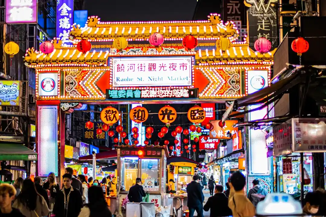 台灣夜市的夜晚街景,充滿了食物攤販和熙來攘往的人潮。
