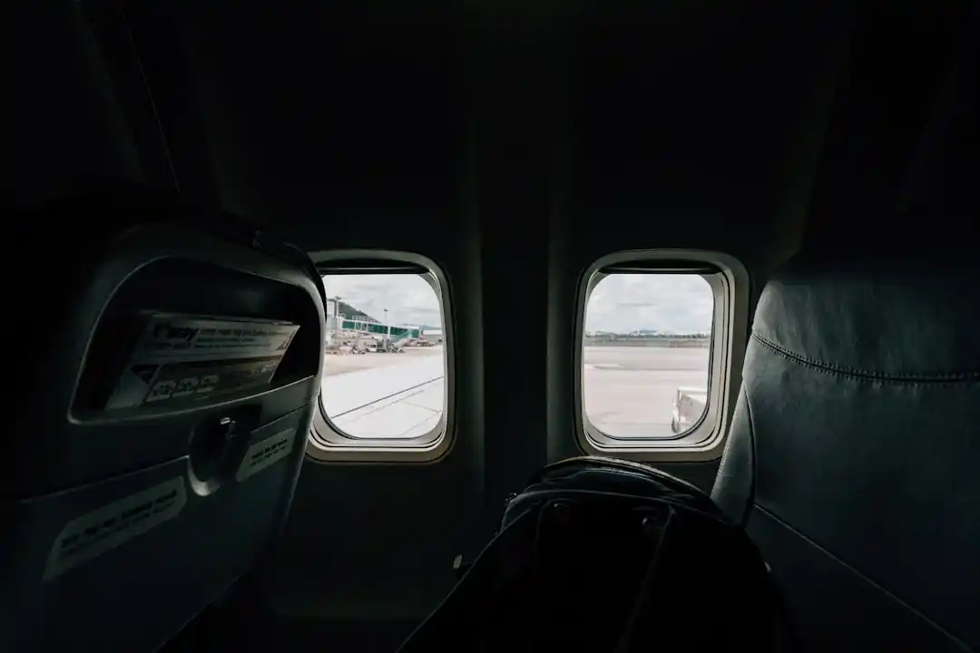 從飛機窗戶向外看的視角,可以看到藍天與機翼。