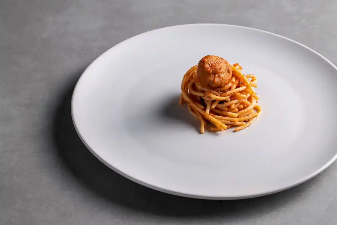 白いお皿に盛り付けられた美味しそうなパスタ