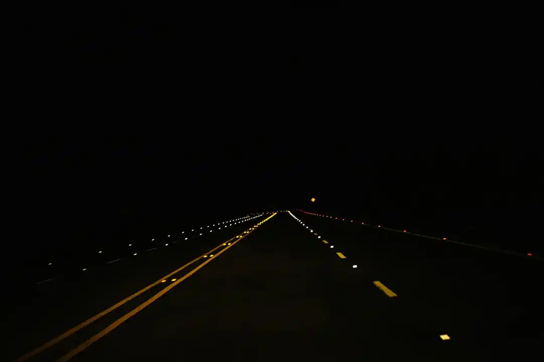 夜の高速道路を走る車の光跡