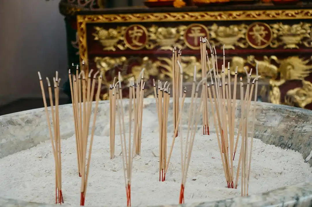 在傳統寺廟的環境中,香爐裡正燃燒著裊裊的香。