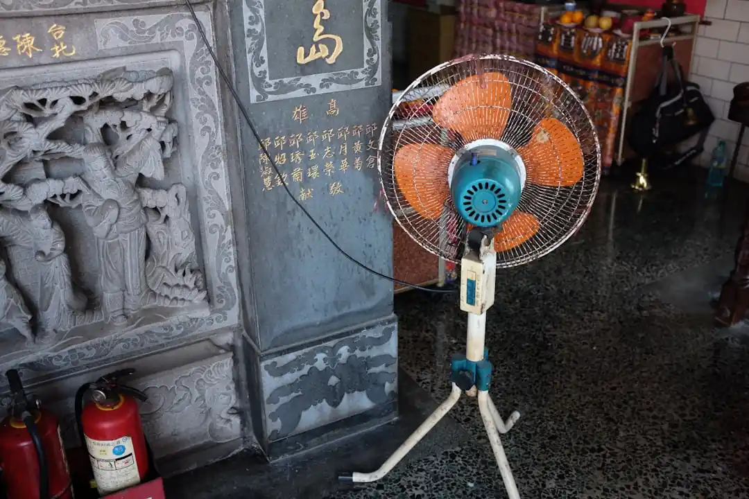 石の彫刻がある部屋に置かれた一台の古い扇風機
