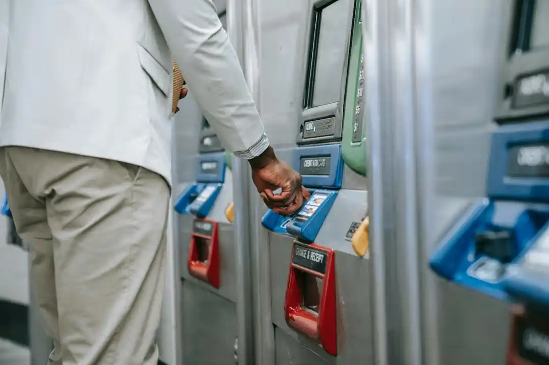 近代的な地下鉄の券売機で切符を購入している男性のクローズアップ