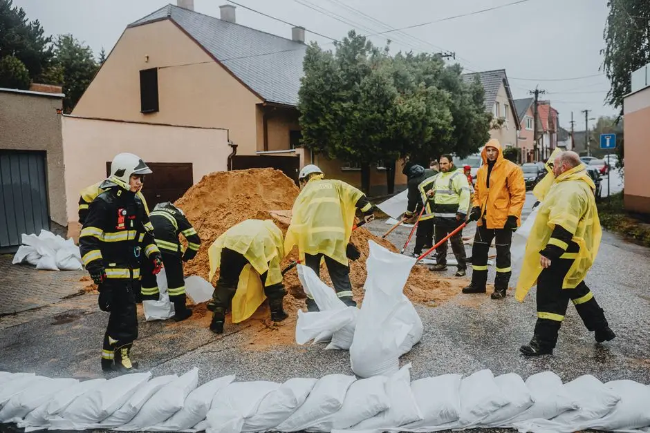 Emergency response team filling sandbags on a rainy street