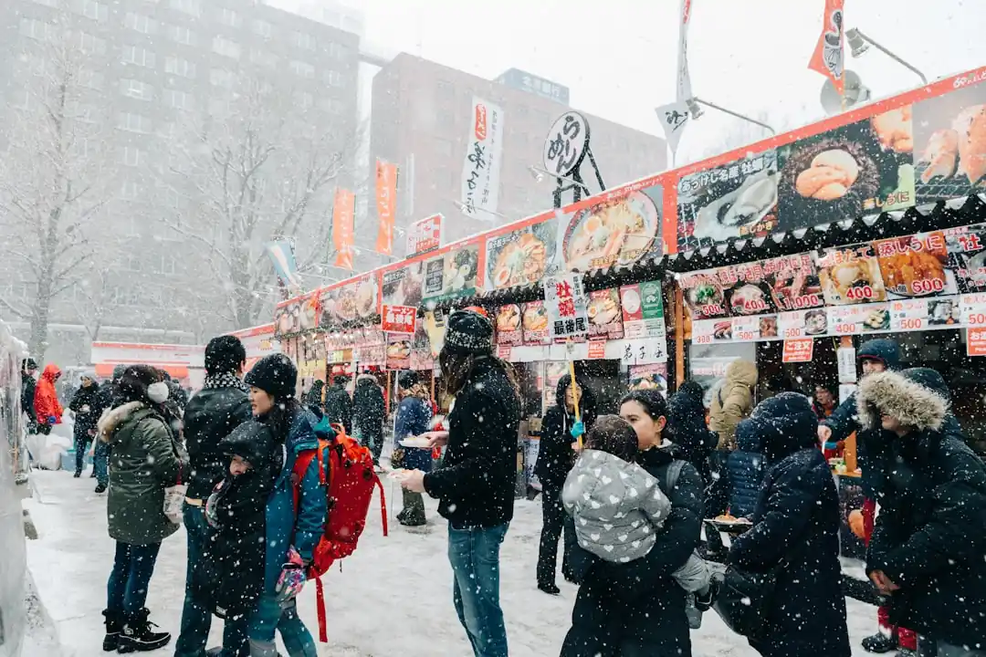 삿포로 눈 축제의 거대한 얼음 조각상 앞에 사람들이 모여있다.